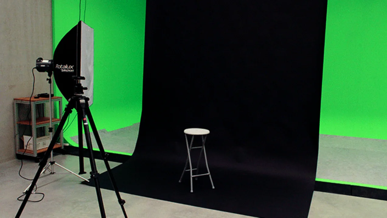 Shot of the photo studio with green screen wall, black background and lighting.