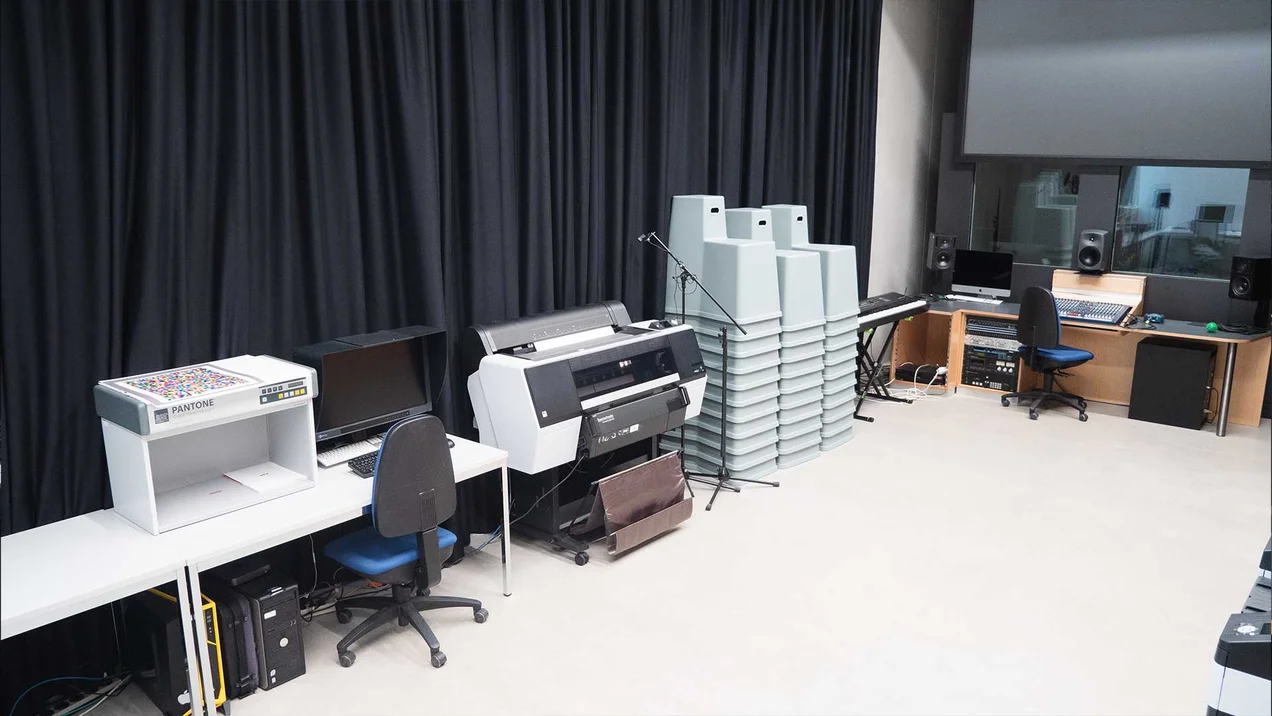 Recording studio with mixing console, sound booth and other equipment.