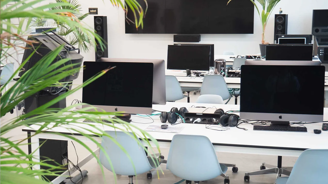 Photo of the Creative Lab with workstations, plants and video wall.